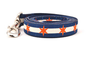 Large dog leash has two outer dark blue stripes and one central off-white stripe and orange six point stars around the collar. 