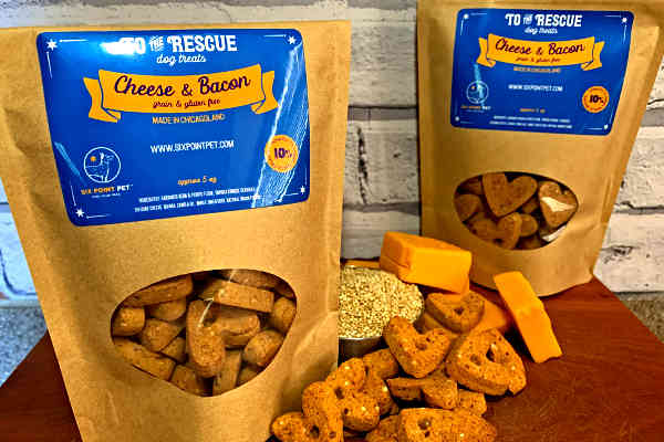 Two bags of Cheese and Bacon treats pictured with cheese and quinoa.