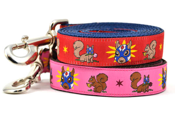 Two dog leashes - one red and one pink - design includes squirrel in lucha libre mask with a yellow flower behind it and a tulip on the mask.  One small squirrel with a tulip in its mouth and one with a tulip bulb.  Also, a six pointed star.