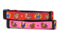 Two dog collars - one red and one pink - design includes squirrel in lucha libre mask with a yellow flower behind it and a tulip on the mask.  One small squirrel with a tulip in its mouth and one with a tulip bulb.  Also, a six pointed star.