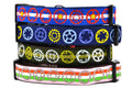 Stack of four dog collars with bicycle sprocket designs.  One is pink with red, white, and green stripes and gray sprockets.  One is green with light green stripe and white, light green, and light blue sprockets.  One is navy with yellow, purple, and gray sprockets.  One has the colors of the colorado flag.