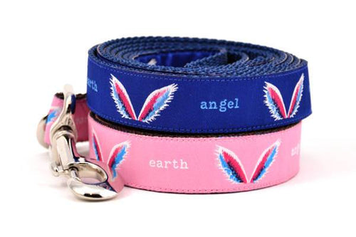 Picture of two dog leashes stacked.  One is pink one is navy with a design that depicts angel wings and words earth angel.
