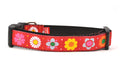 Medium red dog collar with daisy chain pattern and colorful daisy flowers.