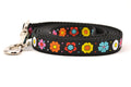 Small black dog leash with daisy chain pattern and colorful daisy flowers.