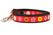 Small red dog leash with daisy chain pattern and colorful daisy flowers.