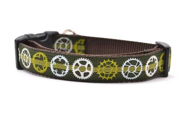 Medium green dog collar with light green stripe and bicycyle sprockets in light green, white and light blue.