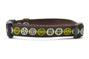 Small green dog collar with light green stripe and bicycyle sprockets in light green, white and light blue.