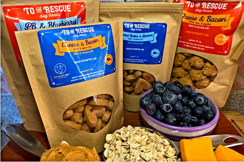 Picture of our "To the Rescue" dog treats all together with peanut butter, blueberries, oatmeal, and cheese also pictured.