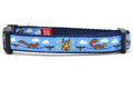 Small light blue dog collar - design includes squirrels running on telephone wires and squirrel in lucha libre mask.  The mask is purple and yellow with electrical sparks coming from the mask.