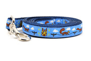 One small light blue dog leash - design includes squirrels running on telephone wires and squirrel in lucha libre mask.  The mask is purple and yellow with electrical sparks coming from the mask.