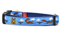 XS light blue dog collar - design includes squirrels running on telephone wires and squirrel in lucha libre mask.  The mask is purple and yellow with electrical sparks coming from the mask.