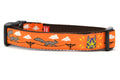 Medium orange dog collar - design includes squirrels running on telephone wires and squirrel in lucha libre mask.  The mask is purple and yellow with electrical sparks coming from the mask.