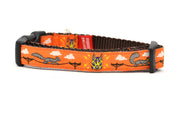 XS orange dog collar - design includes squirrels running on telephone wires and squirrel in lucha libre mask.  The mask is purple and yellow with electrical sparks coming from the mask.