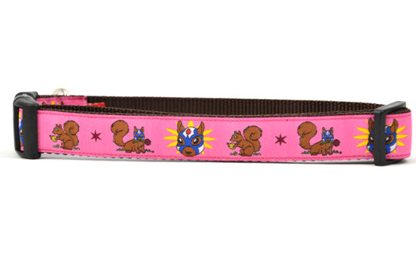 Large pink dog collar - design includes squirrel in lucha libre mask with a yellow flower behind it and a tulip on the mask.  One small squirrel with a tulip in its mough and one with a tulip bulb.  Also, a six pointed star.