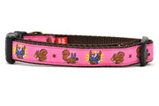 Small pink dog collar - design includes squirrel in lucha libre mask with a yellow flower behind it and a tulip on the mask.  One small squirrel with a tulip in its mough and one with a tulip bulb.  Also, a six pointed star.