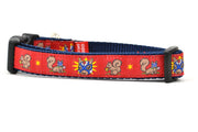Small red dog collar - design includes squirrel in lucha libre mask with a yellow flower behind it and a tulip on the mask.  One small squirrel with a tulip in its mough and one with a tulip bulb.  Also, a six pointed star.
