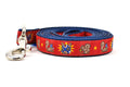 One small red dog leash - design includes squirrel in lucha libre mask with a yellow flower behind it and a tulip on the mask.  One small squirrel with a tulip in its mouth and one with a tulip bulb.  Also, a six pointed star.