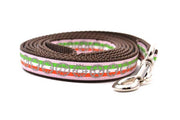 Small pink dog leash with light green, white, and red stripe stripe and gray bicycyle sprockets.