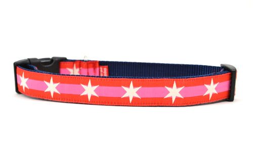 Large dog collar with 2 outer red stripes and 1 pink stripe in the middle and white six pointed stars around the collar.
