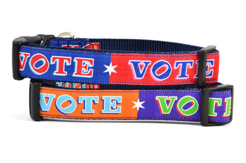 Two dog collars stacked. One is red and navy blocks pattern with the word VOTE on each color block. One is purple and orange blocks pattern with the word VOTE on each color block. 