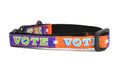 Cat collar that is purple and orange blocks pattern with the word VOTE on each color block. 