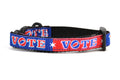 Cat collar that is red and navy blocks pattern with the word VOTE on each color block. 
