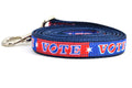 Small dog leash that is red and navy blocks pattern with the word VOTE on each color block.