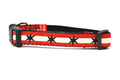 XS dog collar has two outer red stripes and one central off-white stripe and black six point stars around the collar. 